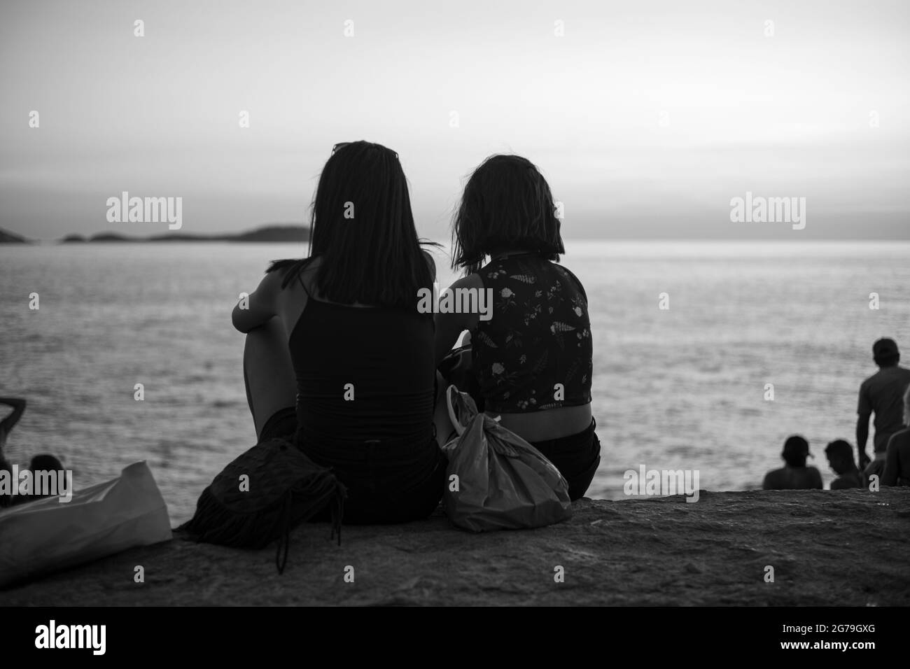 Ein magischer Ort: Die Menschen applaudieren, wenn die Sonne am Arpoador-Felsen untergeht, mit Blick auf den Strand von Ipanema und die Berge von Morro Dois Irmaos und Leblon im Hintergrund. Kamera: Leica M10 Stockfoto