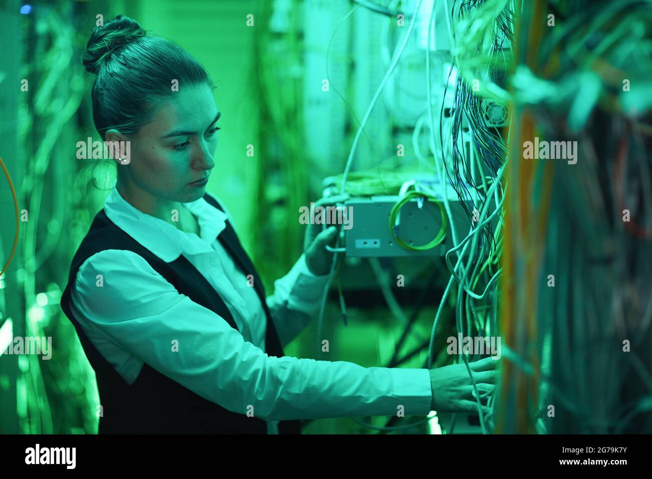 Seitenansicht Porträt einer Netzwerktechnikerin, die mit Servern im Rechenzentrum arbeitet, Kopierbereich Stockfoto