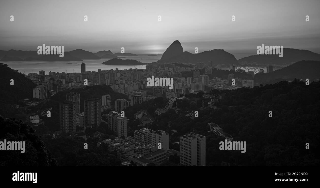 Panoramablick bei Sonnenaufgang auf den Zuckerhut (Morro pao de açúcar) und Bahia de Guanabara mit dem Bezirk Botafogo in Rio de Janeiro, Brasilien Stockfoto