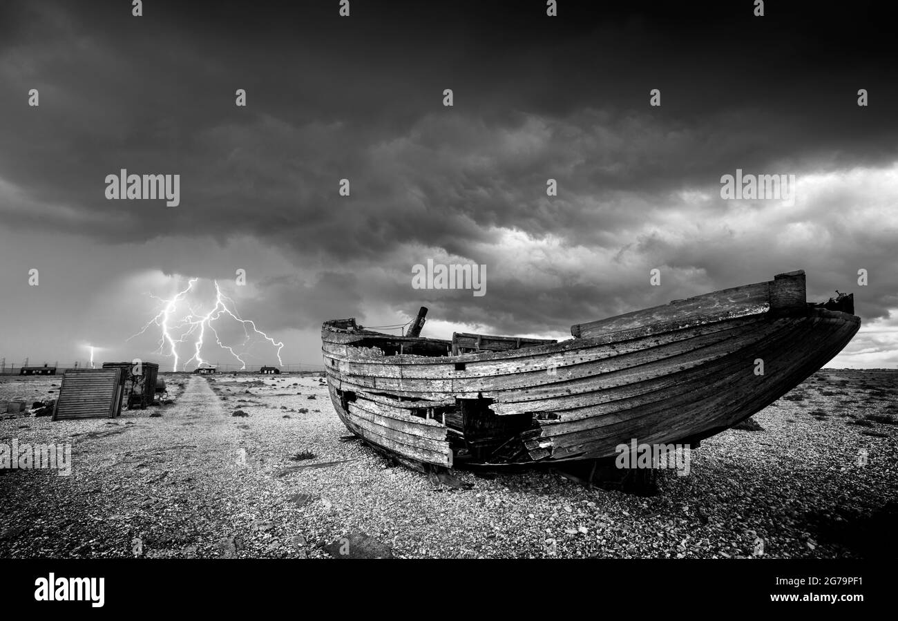 Dungeness Beach Wracked boat on the Shingle Beach with Lightning Storm Dungeness Nature Reserve Kent England GB Europa Stockfoto