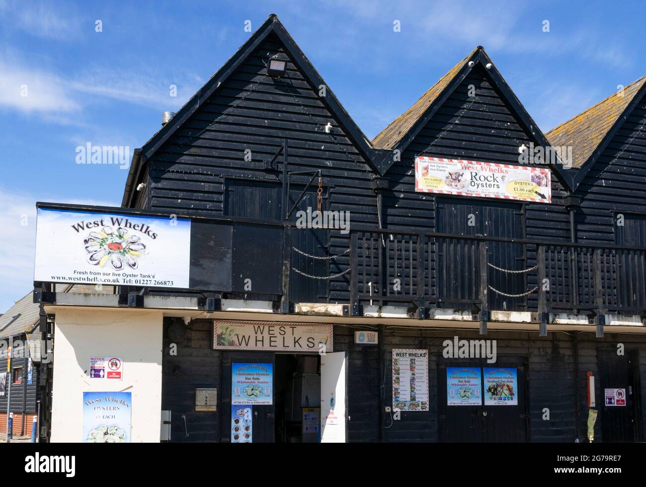 Fischläden in schwarz lackierten Fischerhütten und Austernhütten in Whitstable Harbour Whitstable Kent England GB Europa Stockfoto