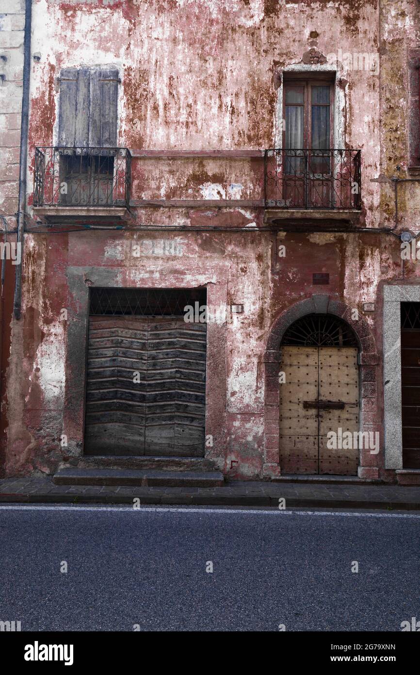 Verwaschene rot-braune Fassade eines verlassenen Wohngebäudes in der Lombardei Stockfoto