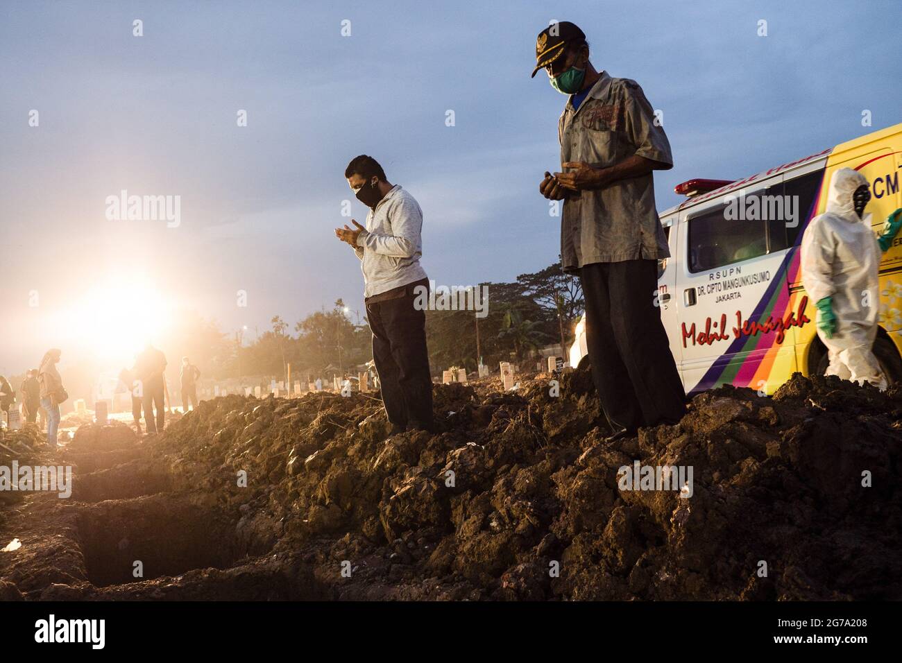 Jakarta, Indonesien. Juli 2021. Familienmitglieder beten während der Beerdigung eines Verwandten auf dem öffentlichen Friedhof von Rorotan. Indonesien hat mit 66,464 Opfern die höchste COVID-19-Todesrate in Südostasien, wie die National Disaster Mitigation Agency berichtet. (Foto: Wisnu Prasetyo/SOPA Images/Sipa USA) Quelle: SIPA USA/Alamy Live News Stockfoto