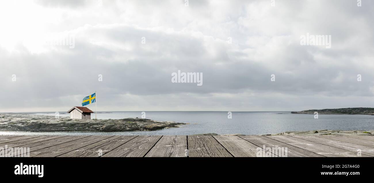 Küste in Schweden mit Hütte und Flagge Stockfoto