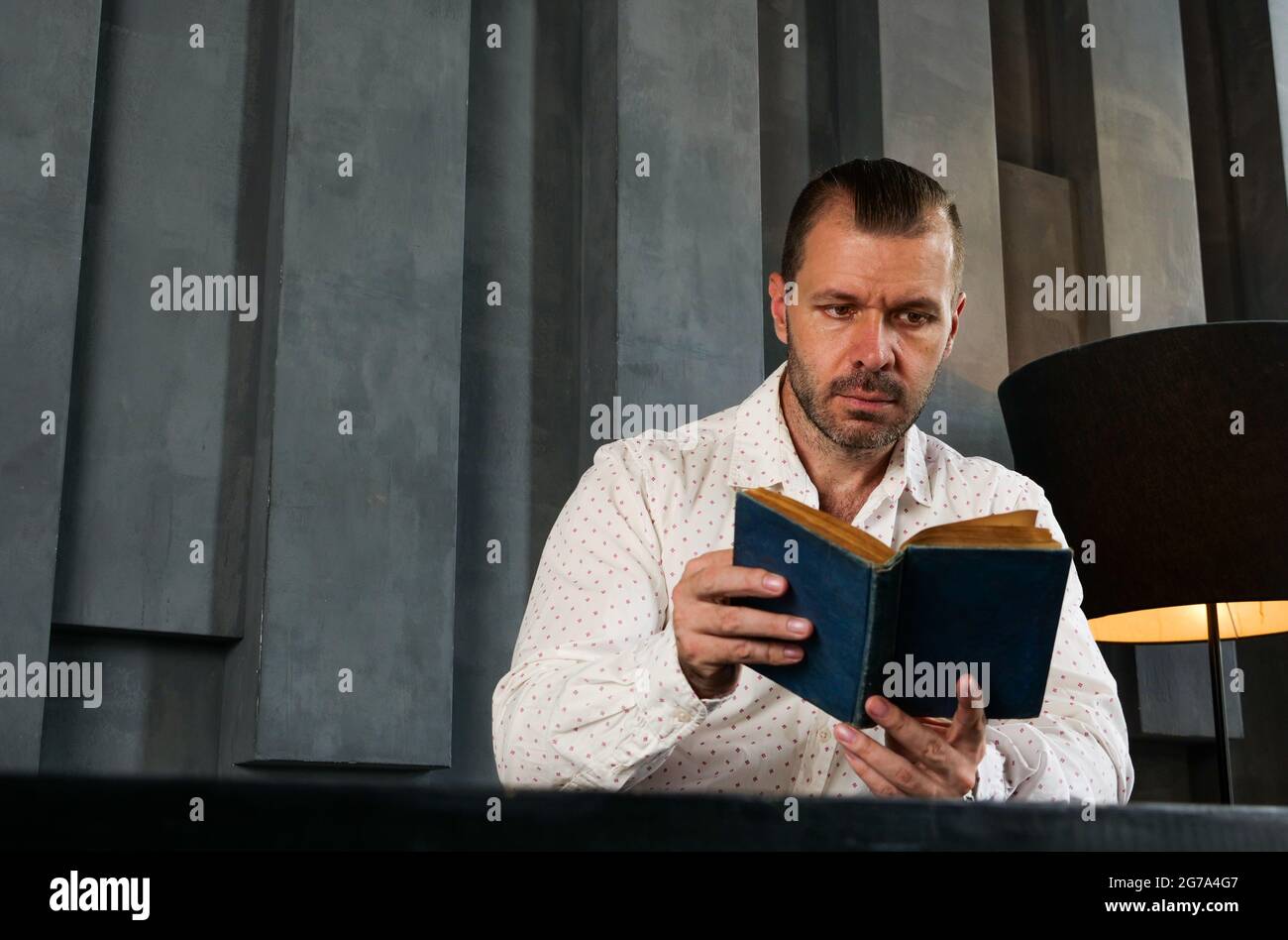 Porträt eines Mannes, der im modernen Raum Buch liest. Wissen und Erfahrung. Stockfoto