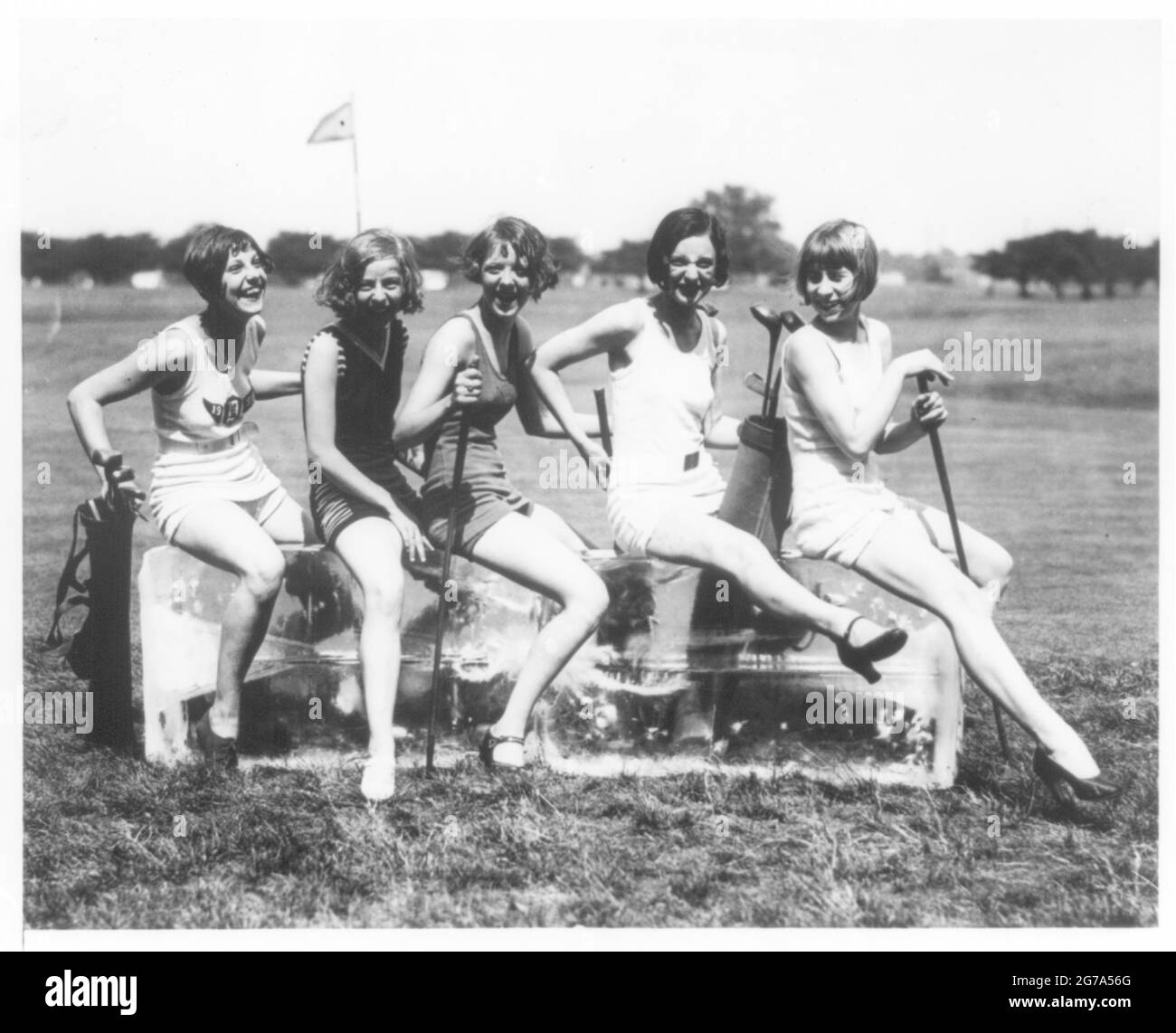 Vintage-Foto mit dem Titel Keeping Cool on the Golf Course - fünf Golfspielerinnen halten sich während der Golfrunde kühl. Stockfoto