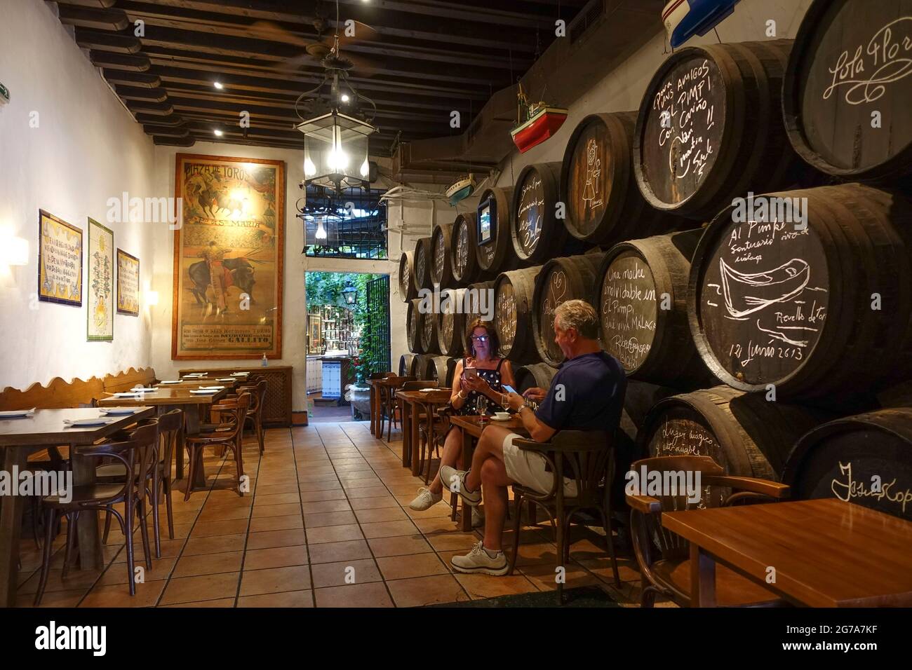 El Pimpi. Menschen, die in einer traditionellen spanischen Bar telefonieren, Bodegas El Pimpi, Malaga, Costa del Sol, Andalusien, Spanien. Stockfoto