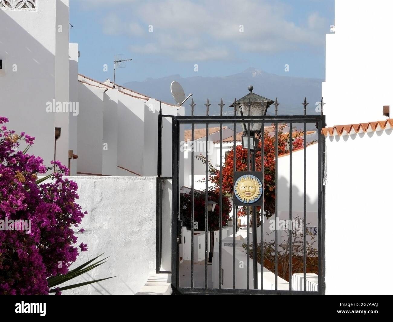 Tor mit Sonnensymbol vor weißen Häusern auf Teneriffa, Spanien, mit Blick auf den Vulkan Teide Stockfoto