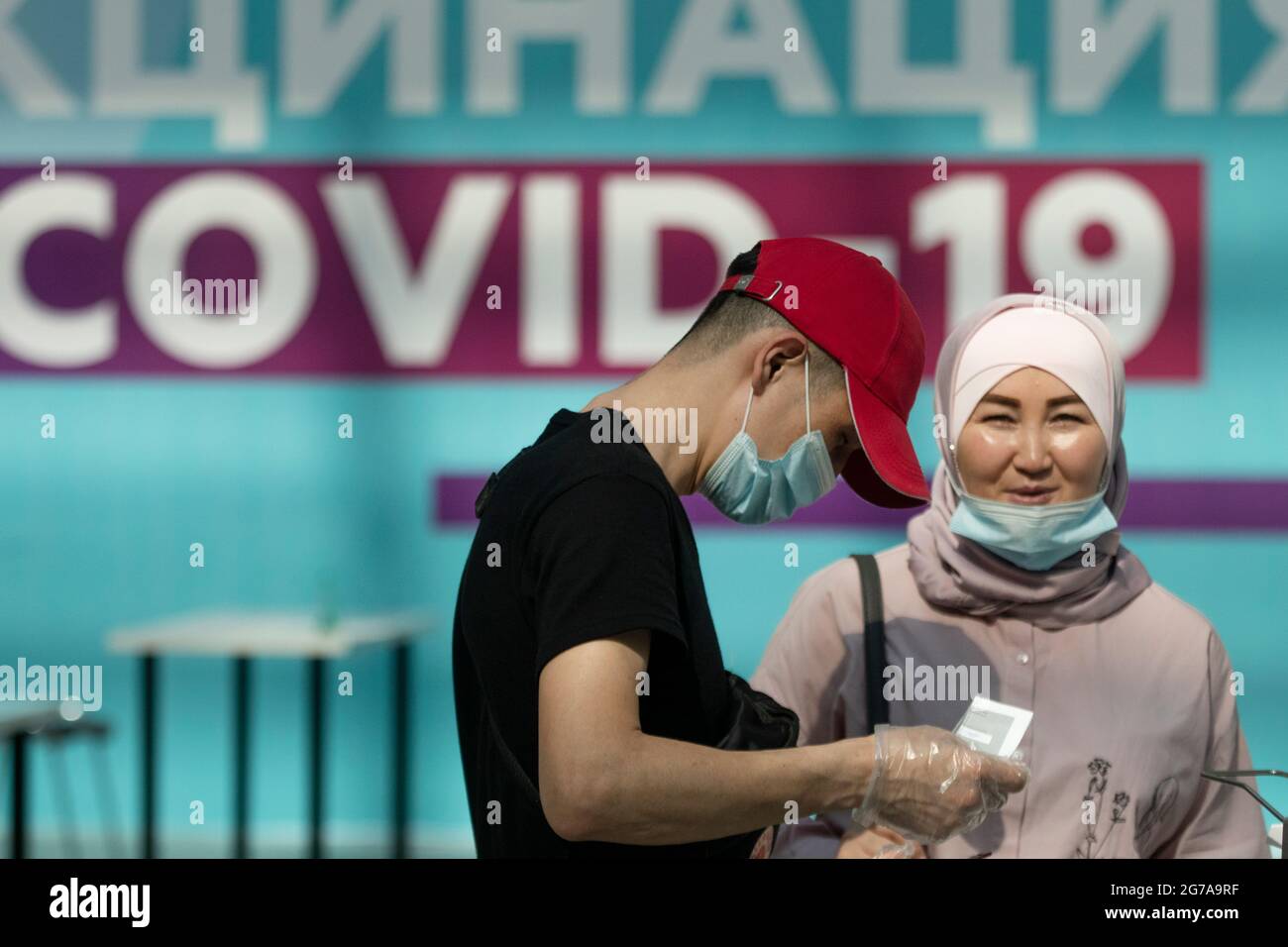 Moskau, Russland. Am 12. Juli stehen 2021 Paare in einer Schlange, die auf die Impfung des Impfstoffes Gam-COVID-Vac (Sputnik V) gegen die neuartige COVID-19-Infektion des Coronavirus warten, und zwar in einem gesunden Moskauer Pavillon, der im Gostiny Dvor Exhibition Center eingerichtet wurde Stockfoto