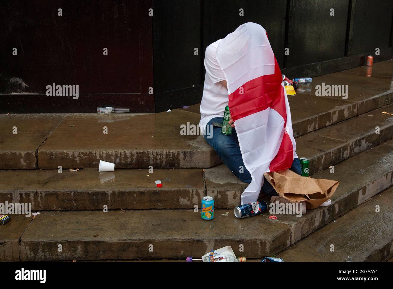 Ein England-Fan versteckt sich unter seiner Flagge, um sich das EM 2020 Finale England gegen Italien anzusehen. Piccadilly Circus, London Stockfoto