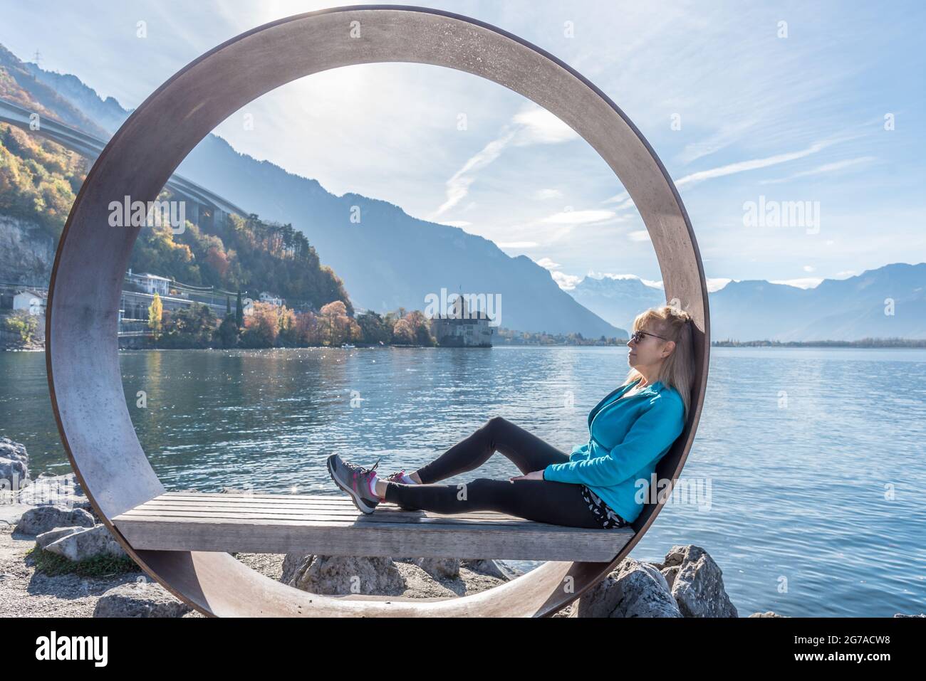 Blonde Frau sitzt im Freien in einem See und entspannt in der Natur. Stockfoto