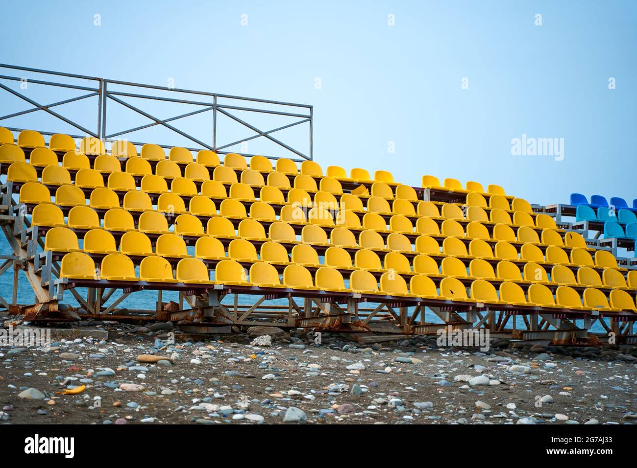 Gelbe Plastiksitze auf dem Podium eines kleinen Sportfeldes. Stockfoto