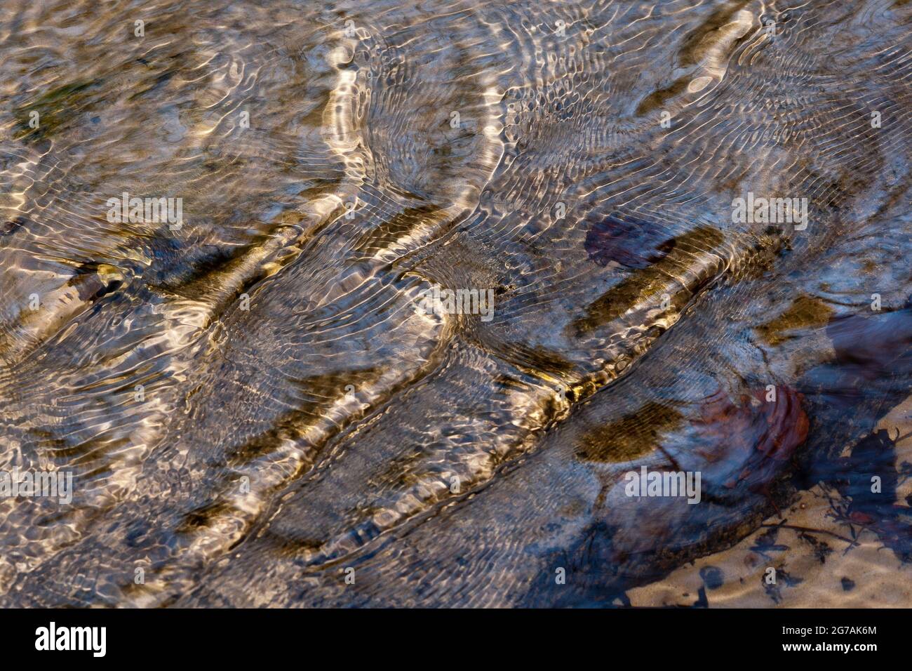 Welligkeit markiert in einem Strom mit Reflexionen des Sonnenlichts im Wasser. Stockfoto