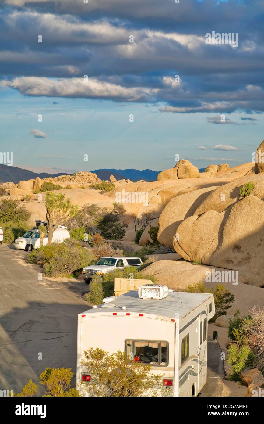 RVS parkte an einem sonnigen Tag inmitten riesiger Felsen im Joshua Tree National Park Stockfoto