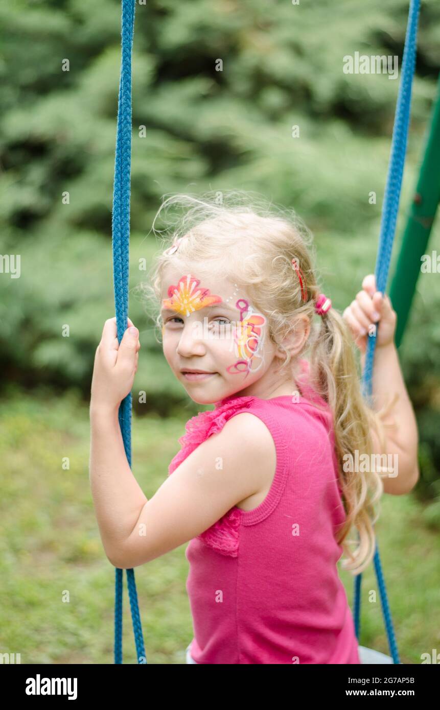 Kleines Kind, das Spaß beim Schaukeln im Park hat Stockfoto