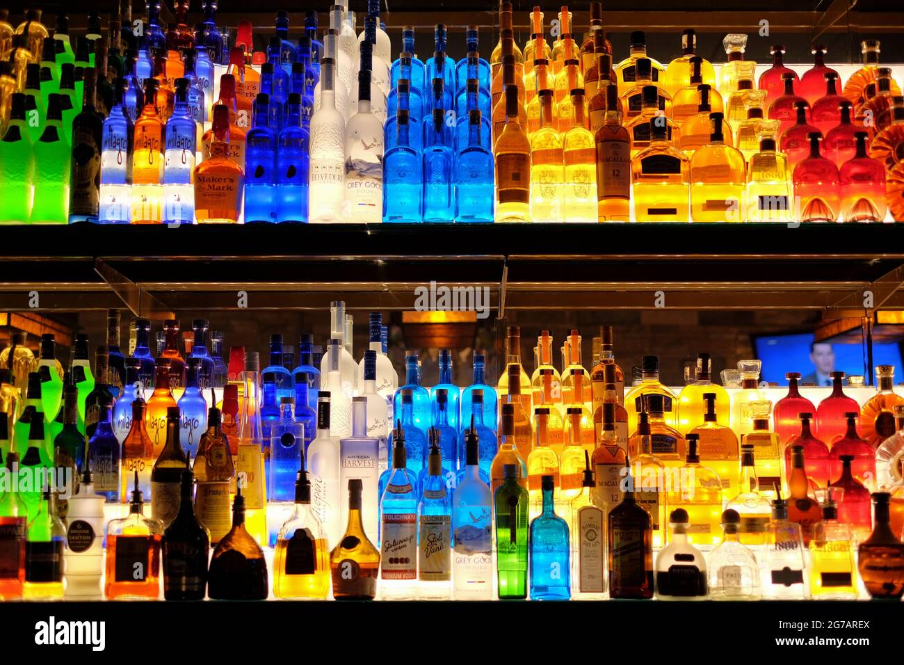 Helle und farbenfroh beleuchtete hintere Barregale mit bunten Alkoholflaschen, die im Firebird Restaurant in Montgomery Alabama, USA, ausgestellt sind. Stockfoto