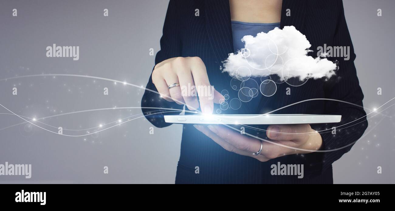 Cloud-Computing-Technologie Internet-Konzept. Weiße Tablette in Geschäftsfrau Hand mit digitalem Hologramm Abstract Cloud-Zeichen auf grauem Hintergrund. Zusammenfassung Stockfoto
