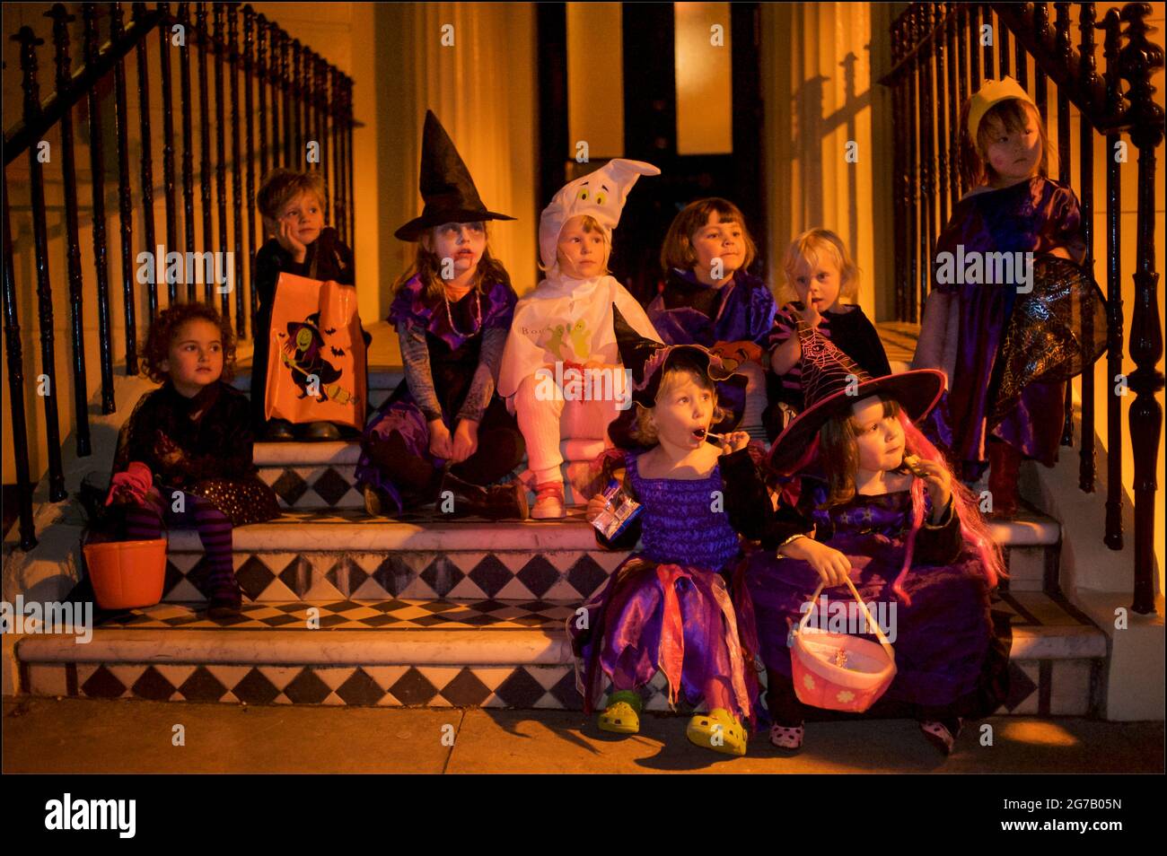 Kinder, die für Halloween verkleidet sind, genießen eine Pause von den Aktivitäten „Trick or Treat“, Brunswick Town, Hove, East Sussex, England, VEREINIGTES KÖNIGREICH. Stockfoto