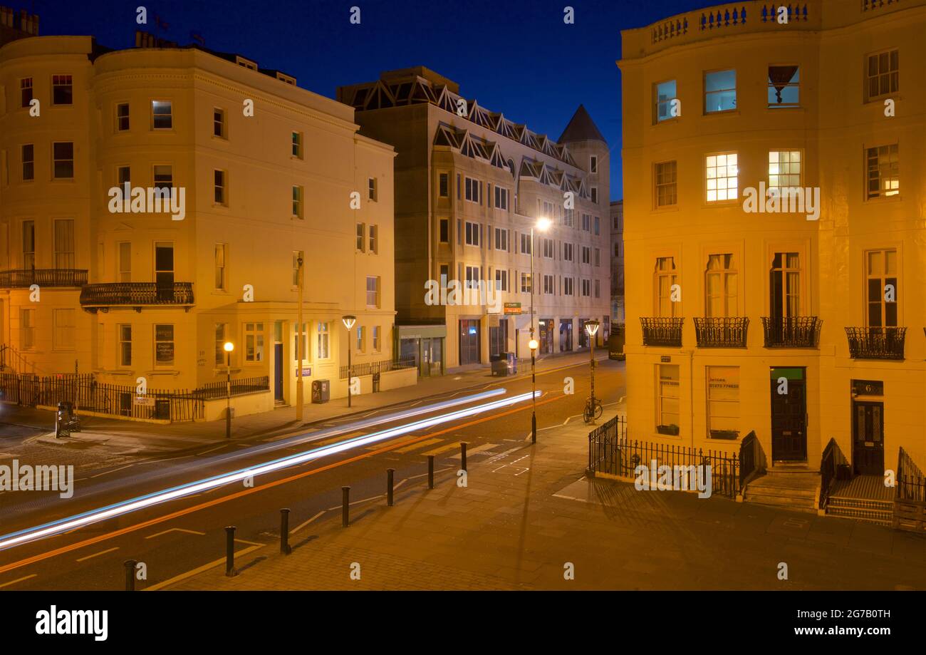 Kreuzung des unteren Teils des Brunswick Place am oberen Ende des Brunswick Square und der Western Road, Hove. Morgendämmerung. Regency-Gehäuse, beleuchtet von Straßenlaternen. Leichte trais vom vorbeifahrenden Straßenfahrzeug. Brighton & Hove, East Sussex, England, Großbritannien Stockfoto