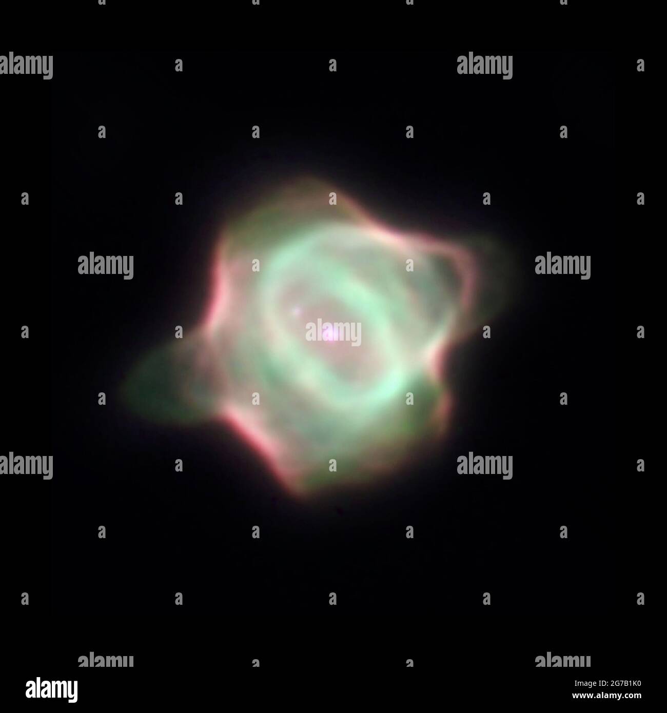 Stingray Nebula (Hen-1357), der jüngste bekannte planetarische Nebel. In diesem Bild befindet sich der helle Zentralstern in der Mitte des grünen Gasrings. Sein Begleitschirm liegt diagonal über ihm bei 10 Uhr. Ein Gassporn (grün) bildet aufgrund der Gravitation eine schwache Brücke zum Begleitstern. Das Bild zeigt auch einen Ring aus Gas (grün) um den zentralen Stern, mit Gasblasen unten links und oben rechts vom Ring. Der Nebel ist so groß wie 130 Sonnensysteme. Eine einzigartige optimierte und verbesserte Version eines NASA-Bildes / Pflichtnachweis: NASA Stockfoto