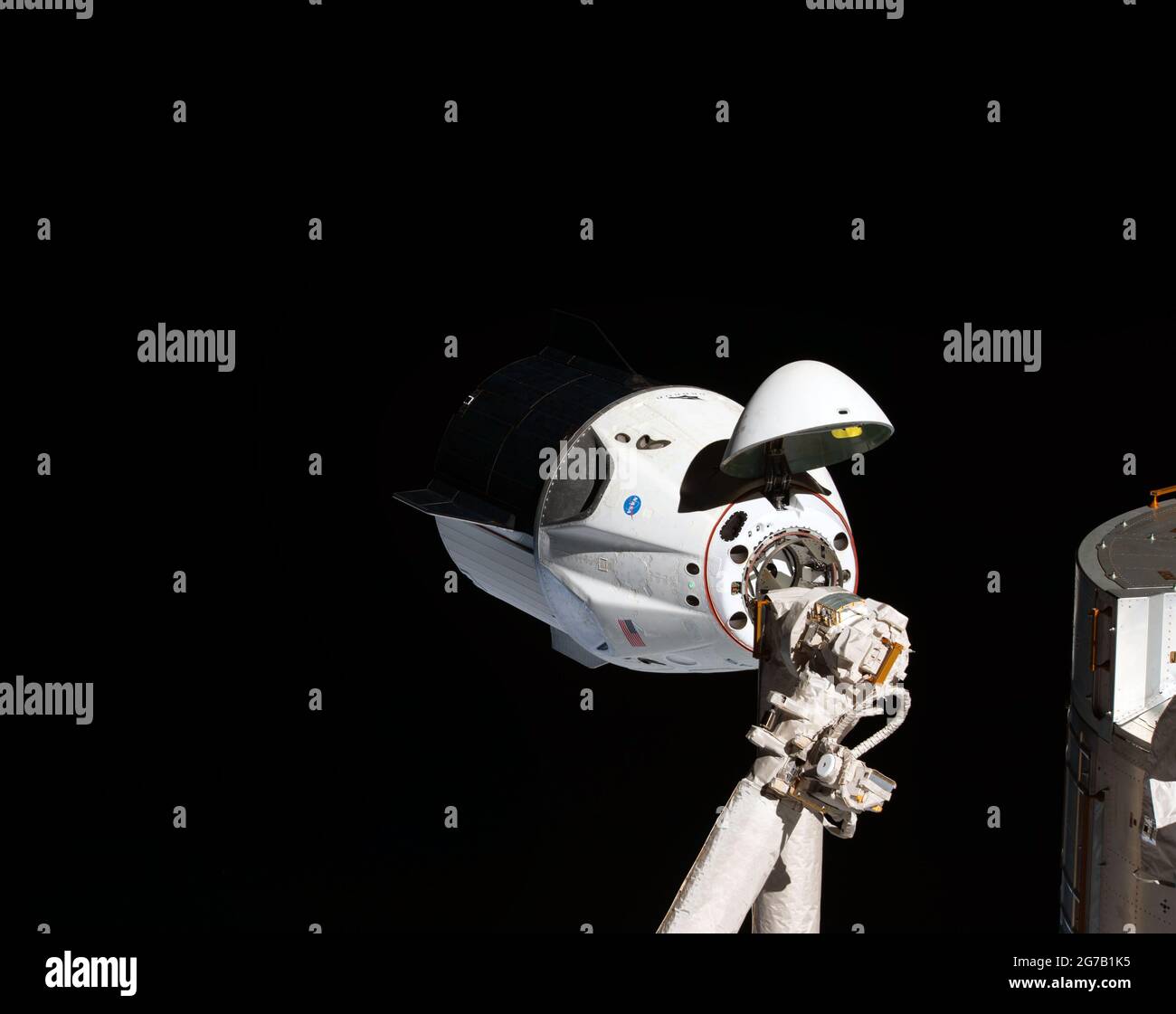 Der erste SpaceX-Drache nähert sich der ISS. Die unbemannte Raumsonde SpaceX Crew Dragon ist das erste Fahrzeug der Commercial Crew, das die Internationale Raumstation besucht. Hier abgebildet mit geöffnetem Nasenkonus, der seinen Andockmechanismus enthüllt, während er sich dem Harmony-Modul der Station nähert. Der Crew Dragon dockte nach wenigen Augenblicken automatisch an den internationalen Docking-Adapter an, der am vorderen Ende von Harmony angebracht war. März 2019. Eine einzigartige optimierte und verbesserte Version eines NASA-Bildes / Pflichtnachweis: NASA Stockfoto