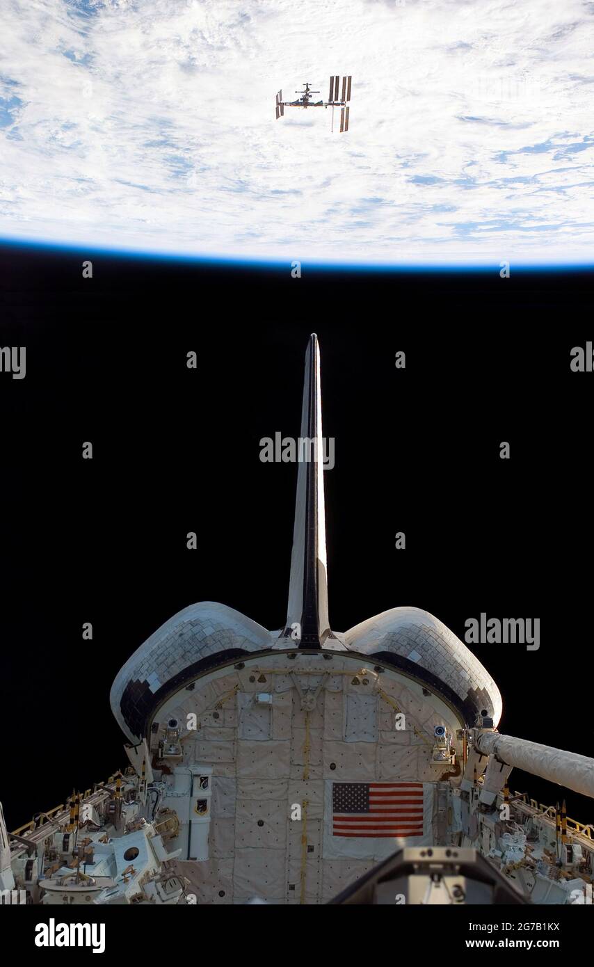 Endeavour verlässt die International Space tation (ISS). Der Horizont der Erde und die Schwärze des Weltraums im Hintergrund erscheint die ISS aus Sicht des Space Shuttle Endeavour sehr klein, während die beiden Raumfahrzeuge ihre relative Trennung durchführen. In diesem Bild sind der vertikale Stabilisator, die OMS-Pods (Orbital Ranging System) und der Nutzlastbereich von Endeavour zu sehen. Eine einzigartige optimierte und verbesserte Version eines NASA-Bildes / Credit NASA Stockfoto