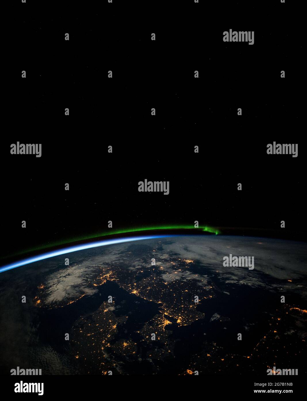 Südskandinavische Länder, fotografiert von Astronauten an Bord der Internationalen Raumstation kurz vor Mitternacht bei Vollmond. Prominente Merkmale sind ein grünes nordlicht im Norden, die Schwärze der Ostsee (unten rechts), Wolken (oben rechts) und Schnee in Norwegen, der unter Vollmond beleuchtet wird. Stadtlichter zeigen deutlich die erkennbare Küste des Skagerrak- und Kattegat-Seewegs, die in die Ostsee führt, die Dänemark von seinen Nachbarn im Norden trennt. Eine einzigartige optimierte und verbesserte Version eines NASA-Bildes / Bildnachweis: NASA Stockfoto