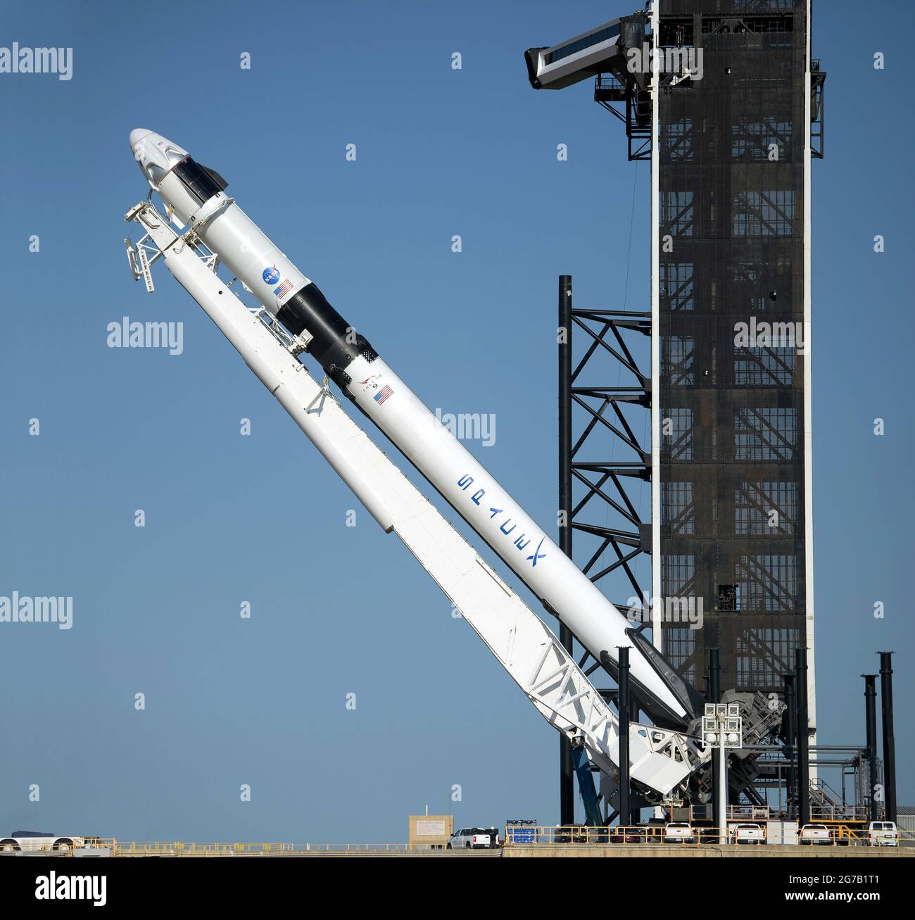 Eine SpaceX Falcon 9-Rakete mit der Crew Dragon-Raumsonde des Unternehmens wird gesehen, als sie für die bevorstehende Demo-2-Mission am 21. Mai 2020 in eine vertikale Position auf der Startfläche gehoben wird. Kennedy Space Center, Florida, USA. Die NASA-Mission SpaceX Demo-2 ist der erste Start mit Astronauten der Raumsonde SpaceX Crew Dragon und der Falcon 9-Rakete zur Internationalen Raumstation. Eine einzigartige, optimierte und digital verbesserte Version eines NASA-Bildes vom Senior NASA-Fotografen Bill Ingalis / Credit NASA Stockfoto