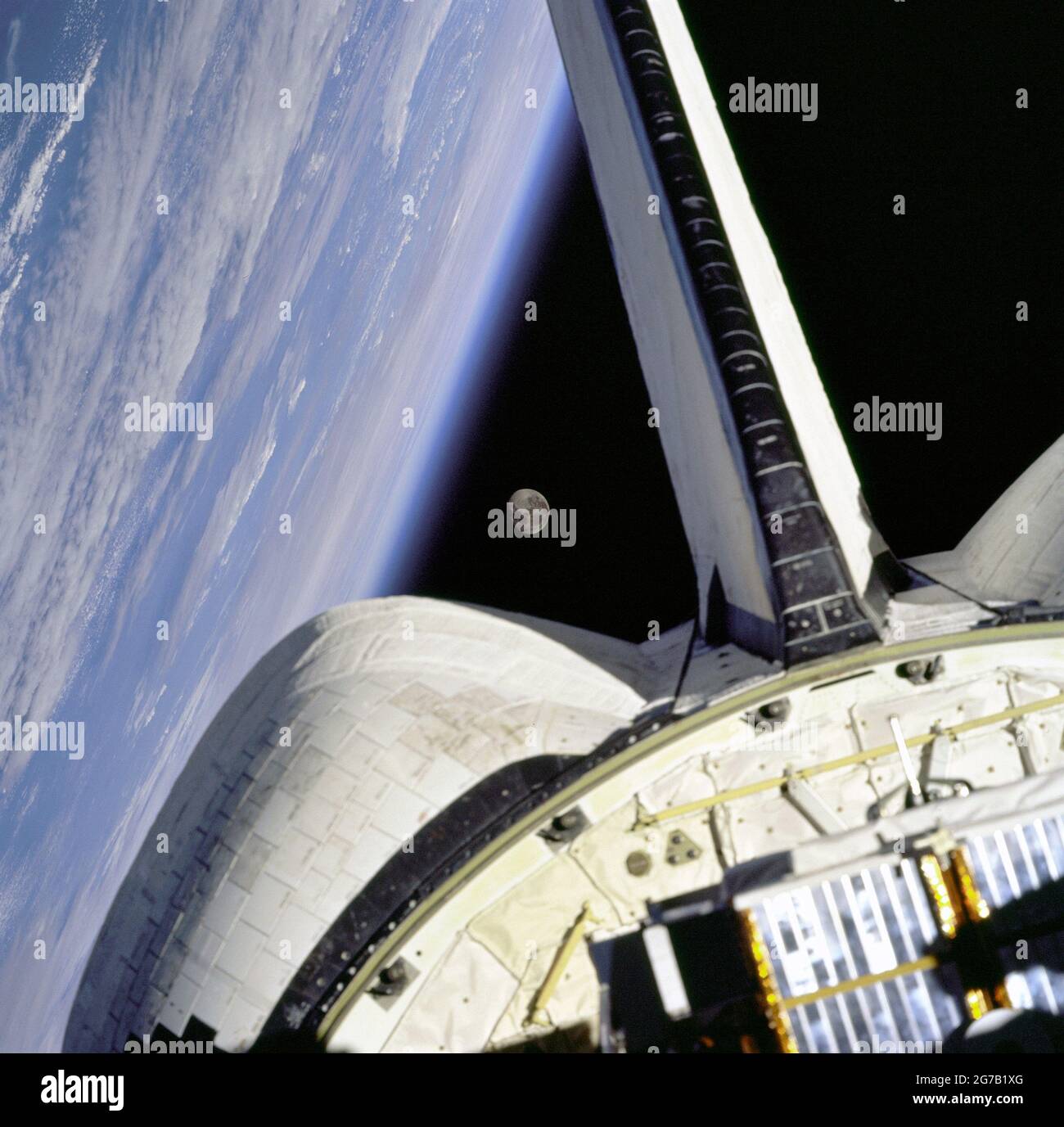 Der Mond gerahmt zwischen der OMS-Kapsel des Orbiters und dem Erdglied über dem Atlantik, aus der Sicht der Fenster an Bord des Space Shuttle Discovery auf der Mission STS-95. Eine optimierte und digital verbesserte Version eines NASA-Bildes/Credit NASA. Stockfoto