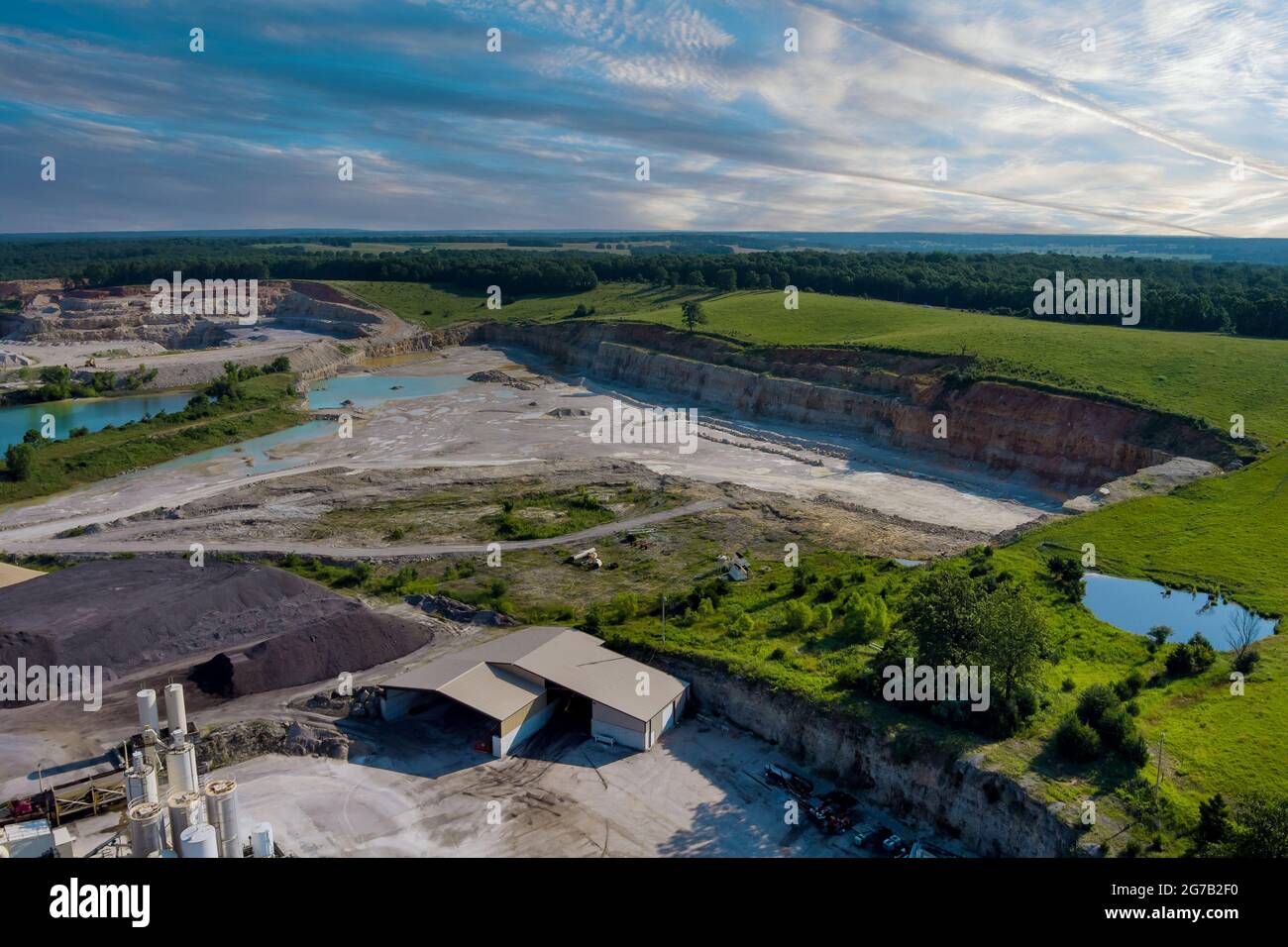 Luftaufnahme des Panorama-Steinbruchs im Tagebau mit vielen Maschinen an Arbeitsgeräten in einer Anlage Stockfoto