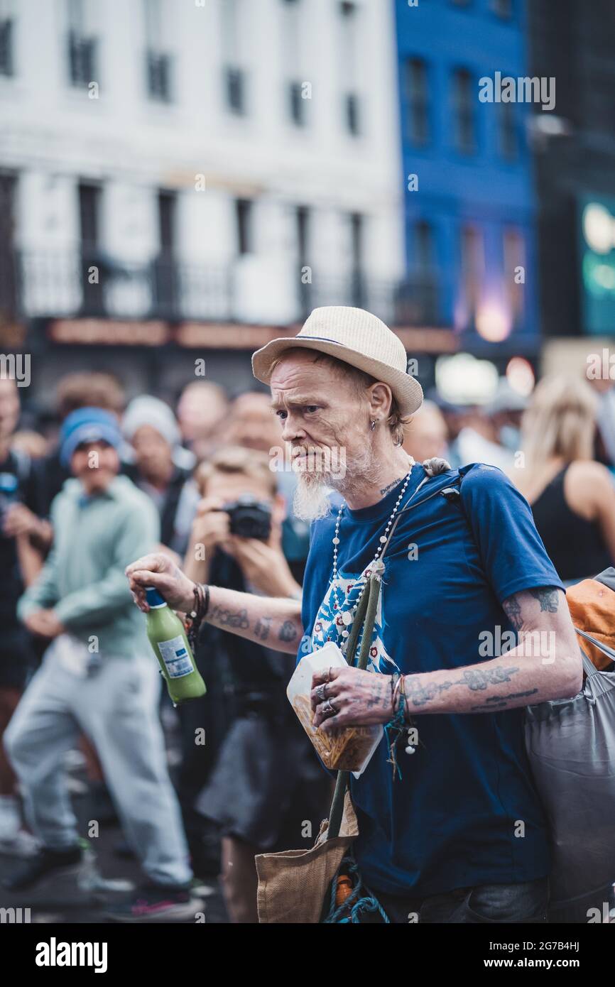 London | UK - 2021.07.12: Mann spritzt Menschen mit einem Bier auf dem Leicaster Square Stockfoto