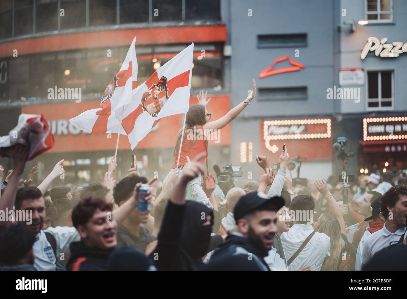 London | UK - 2021.07.12: Englische Fans schwenken vor dem letzten Fußball-Spiel der Euro 2020 Flaggen auf dem Leicester Square Stockfoto