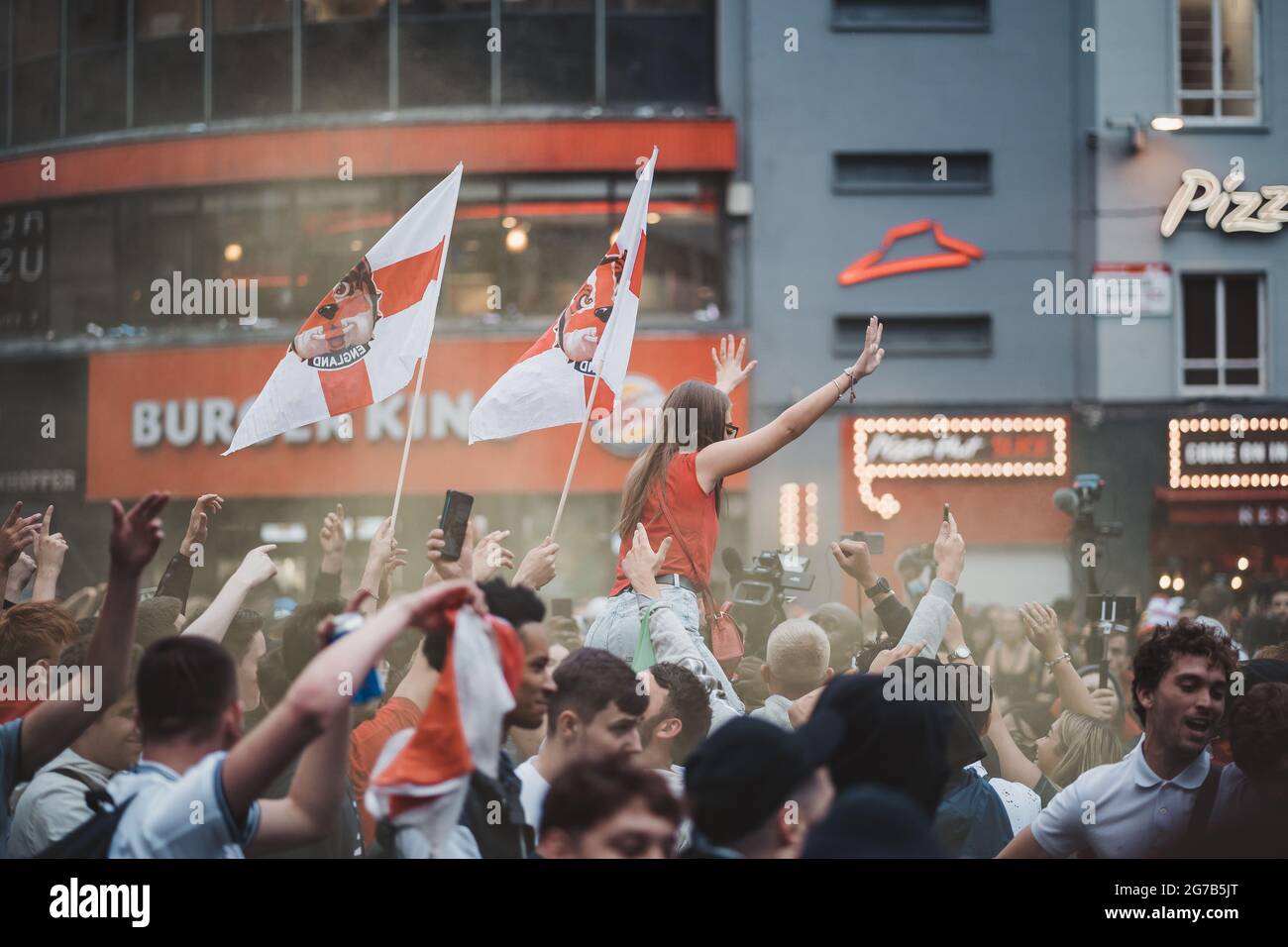 London | UK - 2021.07.12: Englische Fans schwenken vor dem letzten Fußball-Spiel der Euro 2020 Flaggen auf dem Leicester Square Stockfoto