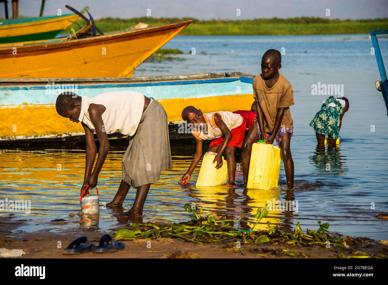 Kinder füllen Wasser in Kanistern am Lake Albert, Uganda, Afrika Stockfoto