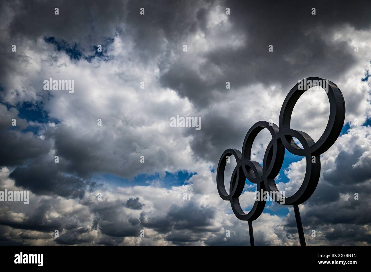 RIO DE JANEIRO - 4. MAI 2016: Olympische Ringe aus Metallic-Silber stehen unter einem dunkelgrauen, wolkigen Himmel. Stockfoto