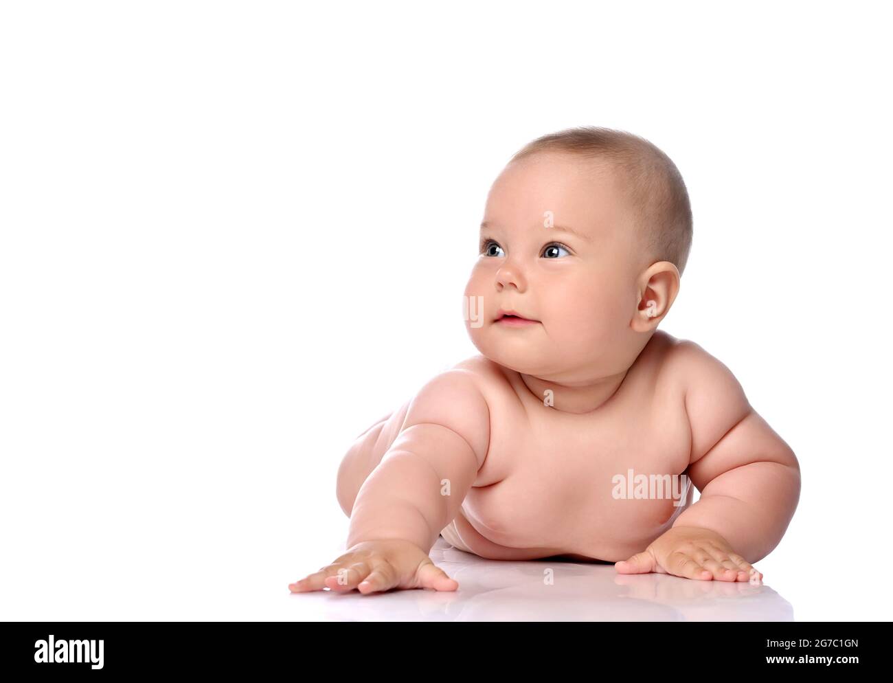 Kleinkind Kind Baby Mädchen Kind in Windel liegt auf ihrem Bauch halten Arm ausgestreckt und schaut zur Seite Stockfoto