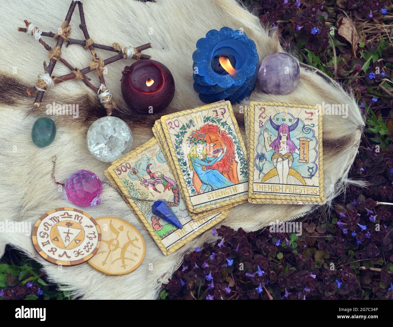 Stillleben mit Tarot-Karten, brennenden Kerzen, Pentagramm und Kristallen draußen. Esoterischer, gotischer und okkulter Hintergrund, Halloween Mystiker und Wicca Conce Stockfoto