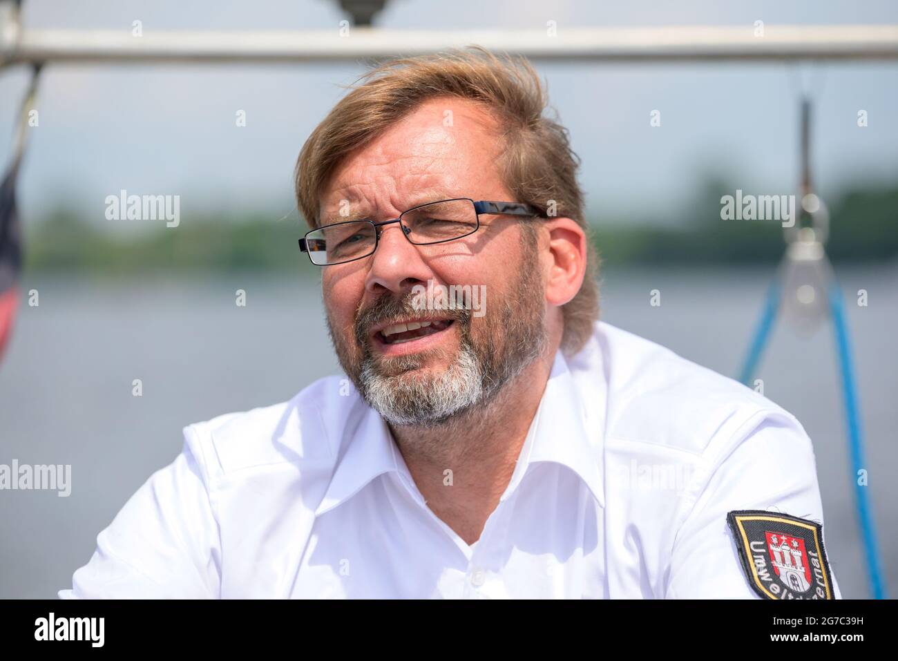 Hamburg, Deutschland. Juli 2021. Vater Schwan Olaf Nieß segelt sein Boot auf der Außenalster. Die Hamburger Alster-Schwäne haben endlich Nachwuchs bekommen. "Wir sind im Moment etwa zehn Küken. Aber es ist noch ein bisschen offen", sagte Schwanenvater Olaf Nieß. Quelle: Jonas Walzberg/dpa/Alamy Live News Stockfoto