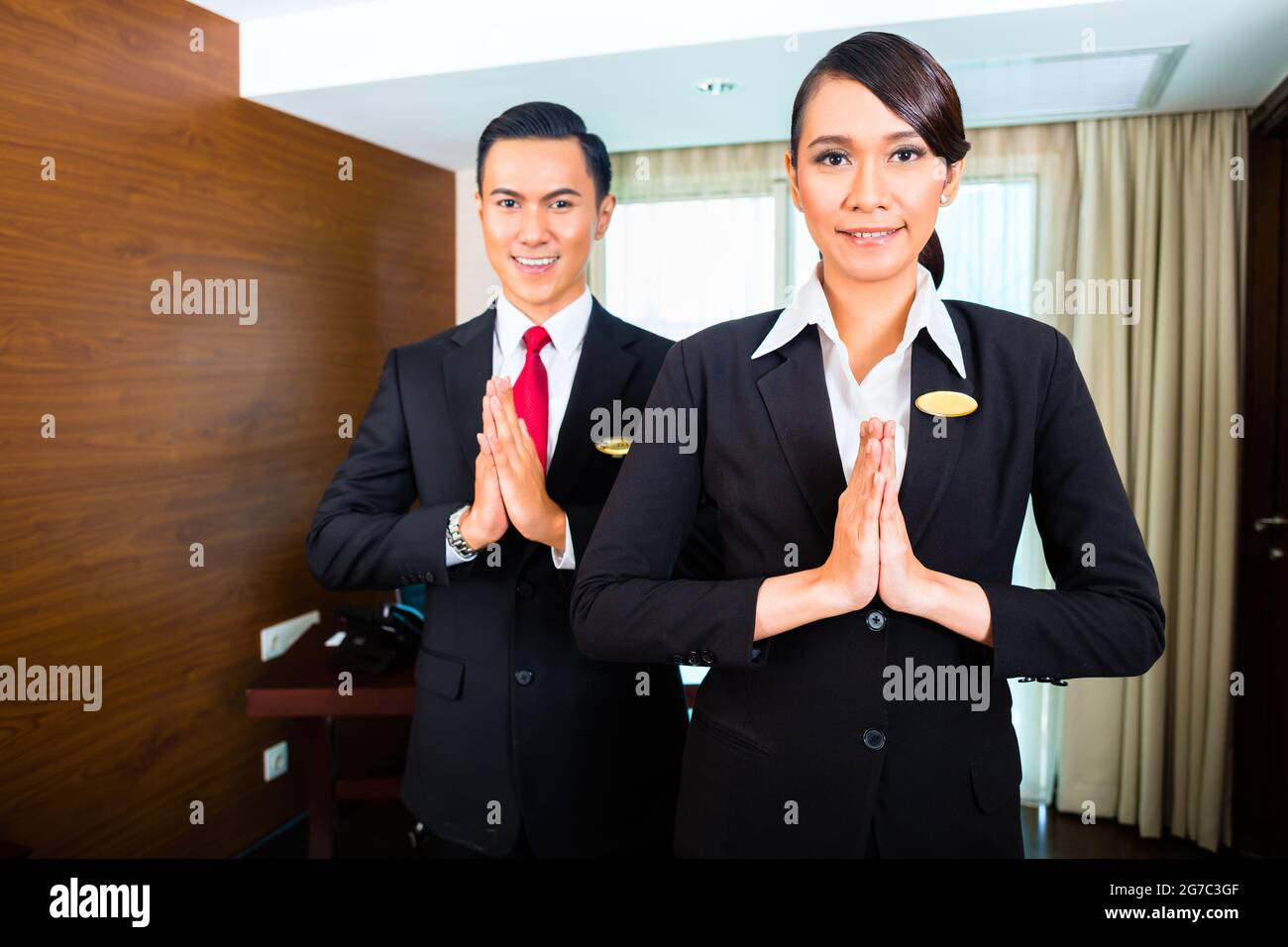 Porträt von Hotel Personal Gruß mit Händen zusammen Stockfoto