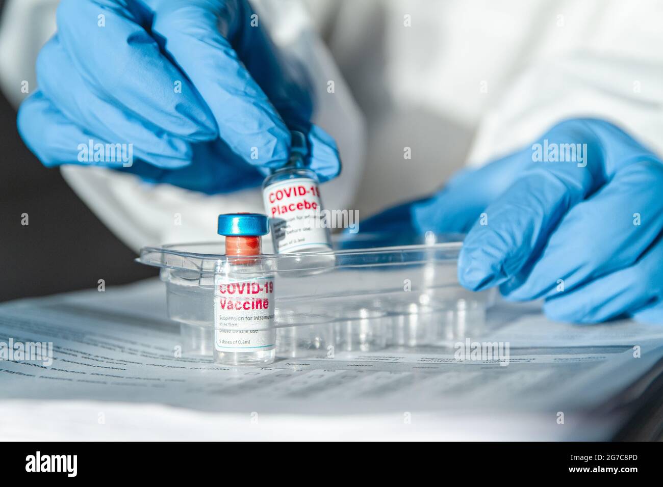 Arzt oder Krankenschwester in Schutzanzug mit Covid-19-Impfstoff und Stockfoto