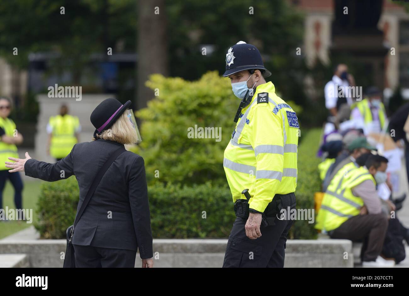 London, England, Großbritannien. Polizeibeamter, der am 2021. Juli mit einem Touristeninformationsführer auf dem Parliament Square in Sprechchöre einging Stockfoto