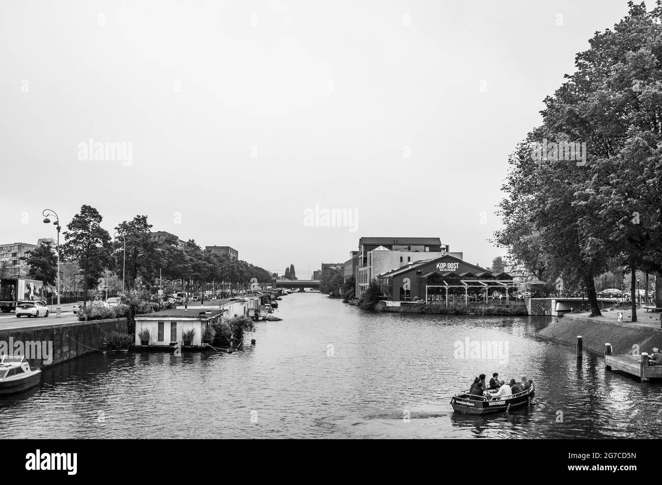 AMSTERDAM, NIEDERLANDE. 06. JUNI 2021. Schöner Blick auf einen Schiffskanal und Brücken. Schwarzweiß-Fotografie. Kleine Boote, Schiffe und Bargen Stockfoto