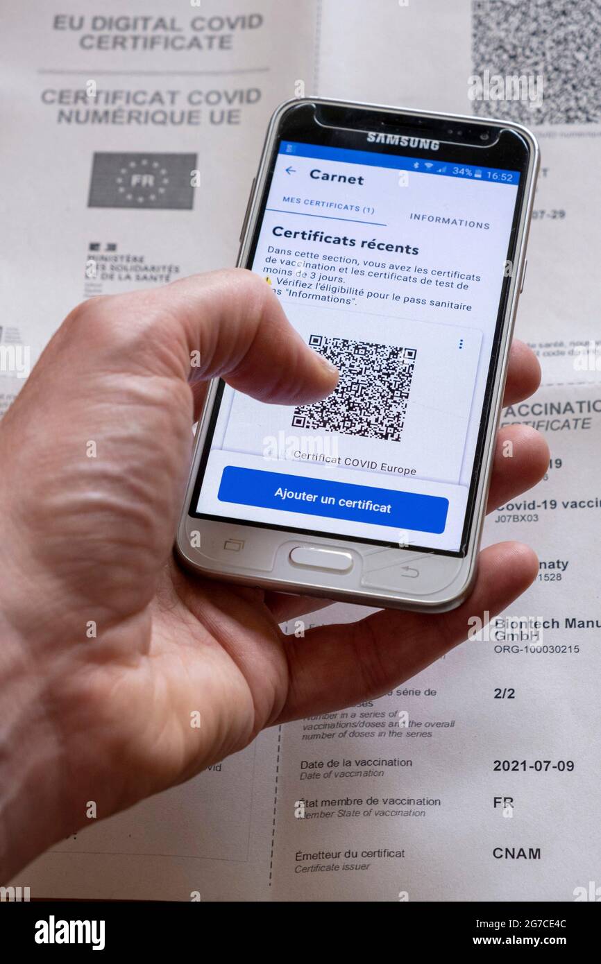 EU-Impfpass für Coronaviren und digitales Covid-Zertifikat der EU. Impfpass, der nach der Injektion der zweiten Dosis des Pfizer-Impfstoffs gegen Covid-19 mit QR-Code ausgestellt wurde, um Ihren Gesundheitsausweis zu erhalten. Papierdokument und QR-Code auf dem Smartphone über die Anwendung „Tous anti covid“. Frankreich am 10. Juli 2021. Foto von Matarezo/ANDBZ/ABACAPRESS.COM Stockfoto