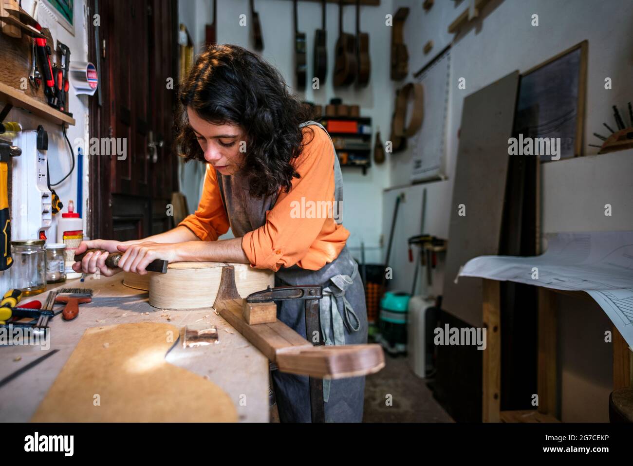Eine Geigenbauerin, die in ihrer Musikinstrumentenwerkstatt Gitarren macht Stockfoto