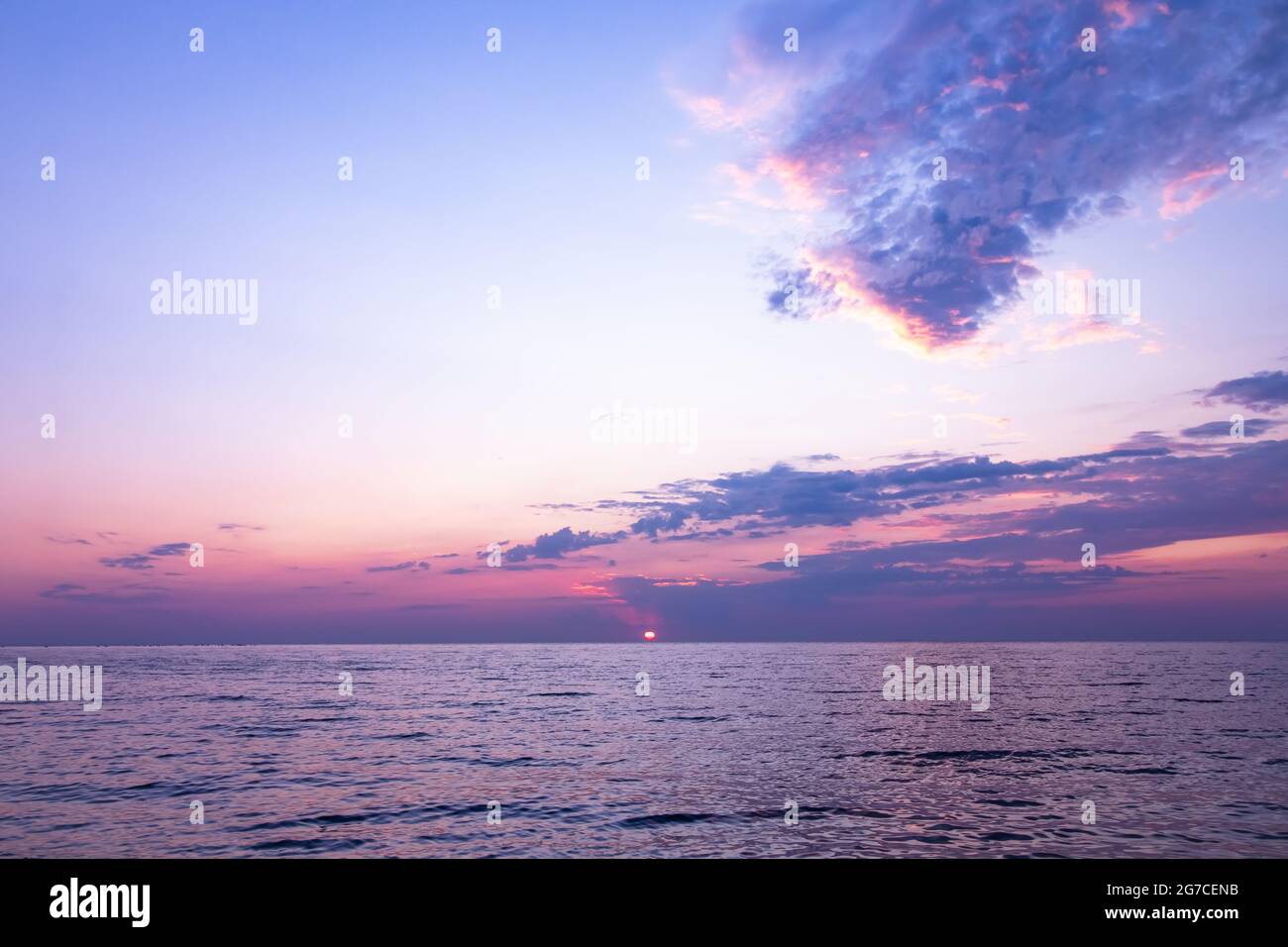Violetter Sonnenaufgang über dem Meer. Skyline, Meereslandschaft. Sommer tropische Natur. Wunderschöne Landschaft, Meereswellen am Morgen. Reisekonzept. Rosafarbener Himmel mit Klo Stockfoto