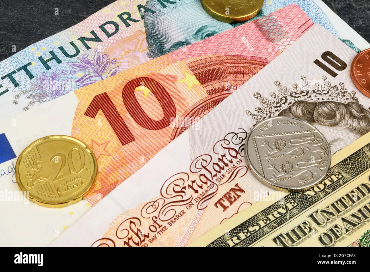 Euro-, American Dollar-, Schwedische Kronen- und britische Sterling-Scheine und -Münzen auf Schieferhintergrund. Stockfoto