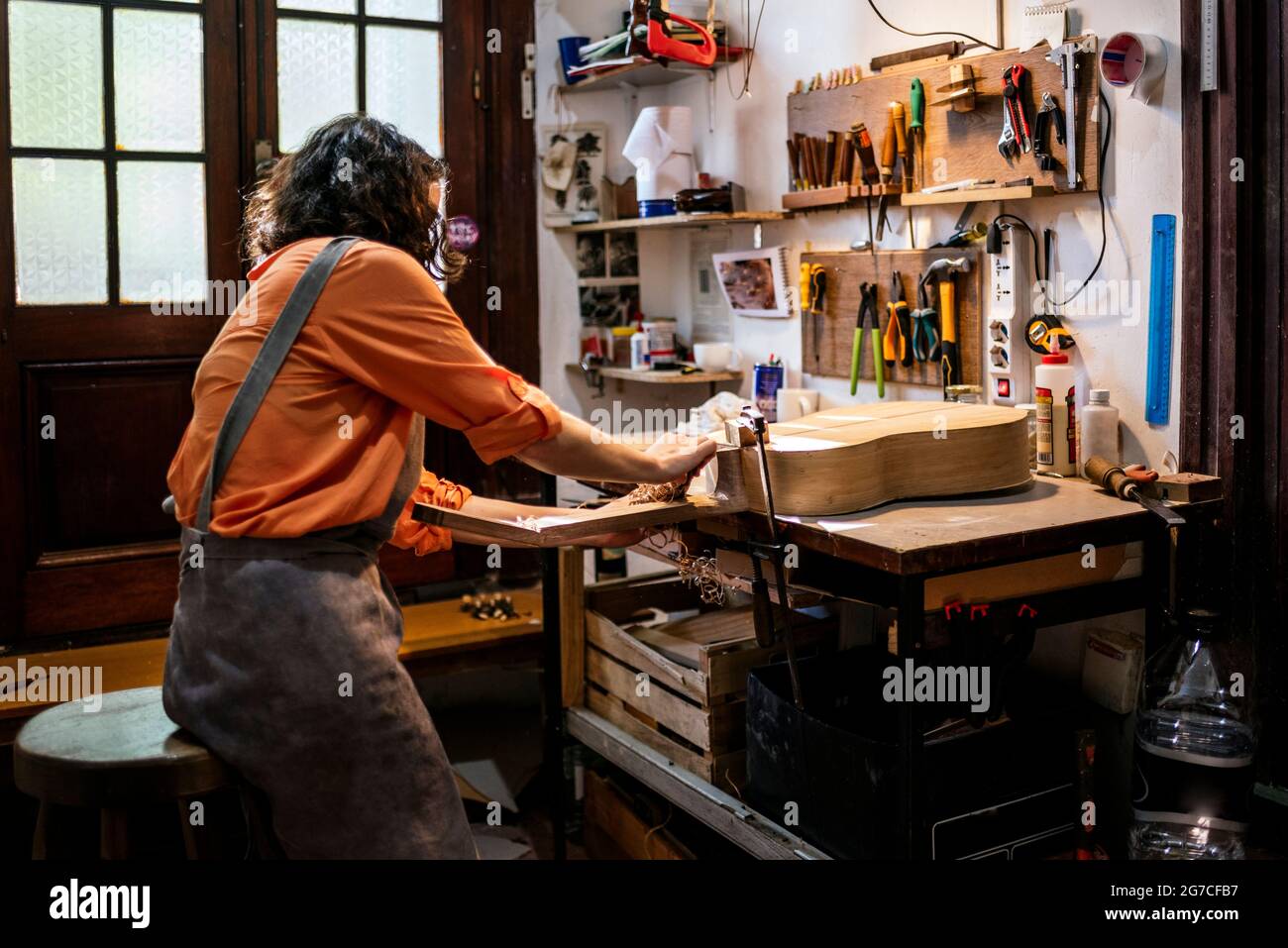 Unbekannte Frau in ihrer Geigenbauwerkstatt. Stockfoto