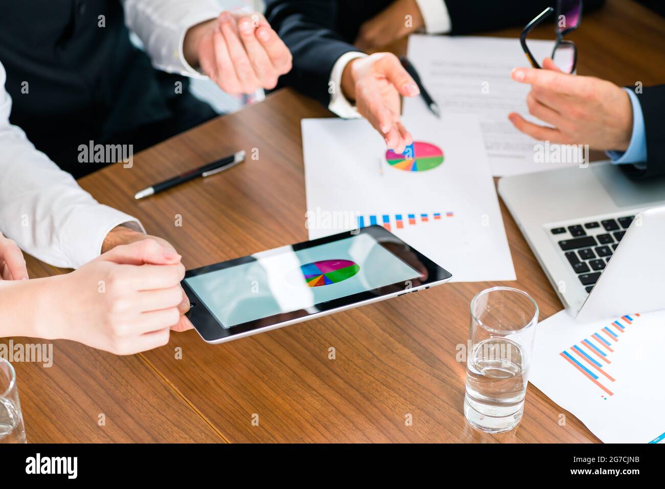 Unternehmen - Banker, Manager oder Experte in Meetings bewertet die Zahlen auf Tablet-Computer und vergleicht die Entwicklung des Unternehmens zu beraten und ac Stockfoto