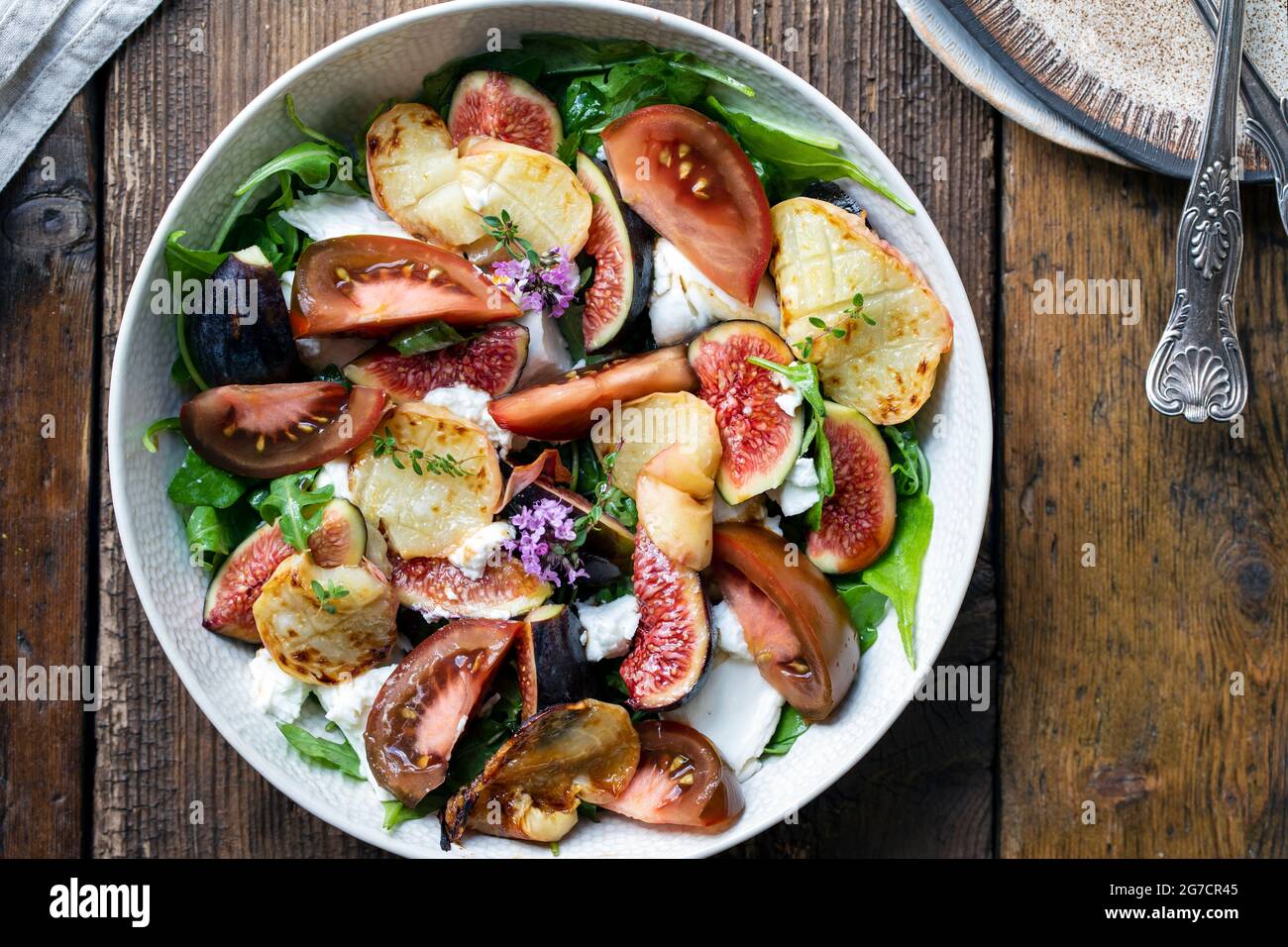 Frische Feigen und Mozzarrella-Käsesalat mit gegrillten Pfirsichscheiben und Tomaten Stockfoto