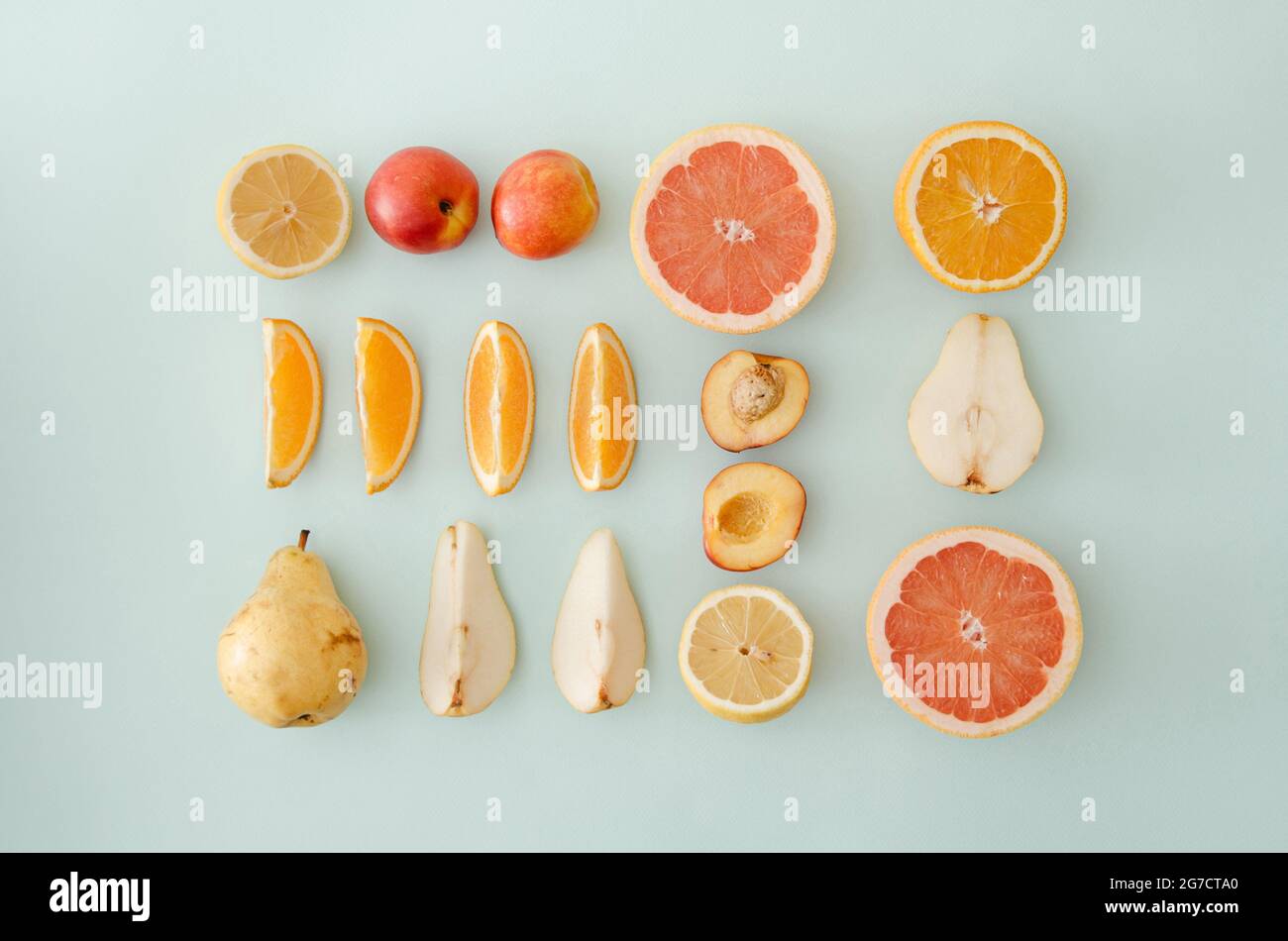 Ordentlich angerichtet frisches Obst auf blauem Hintergrund. Minimale flache Verlegung. Stockfoto